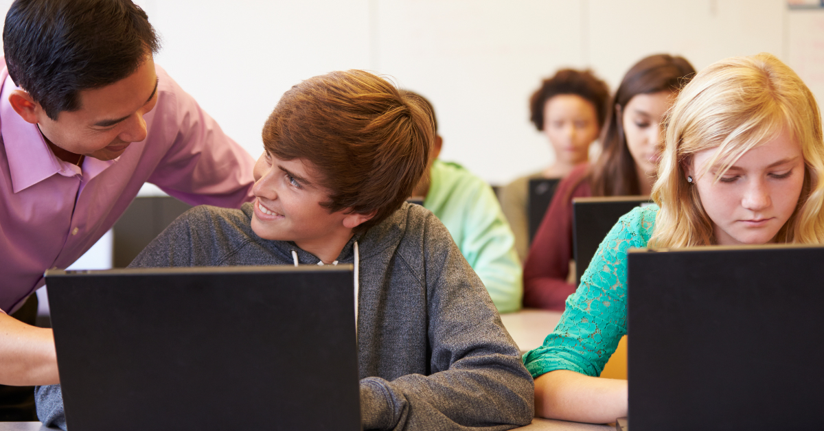 student on laptop with teacher