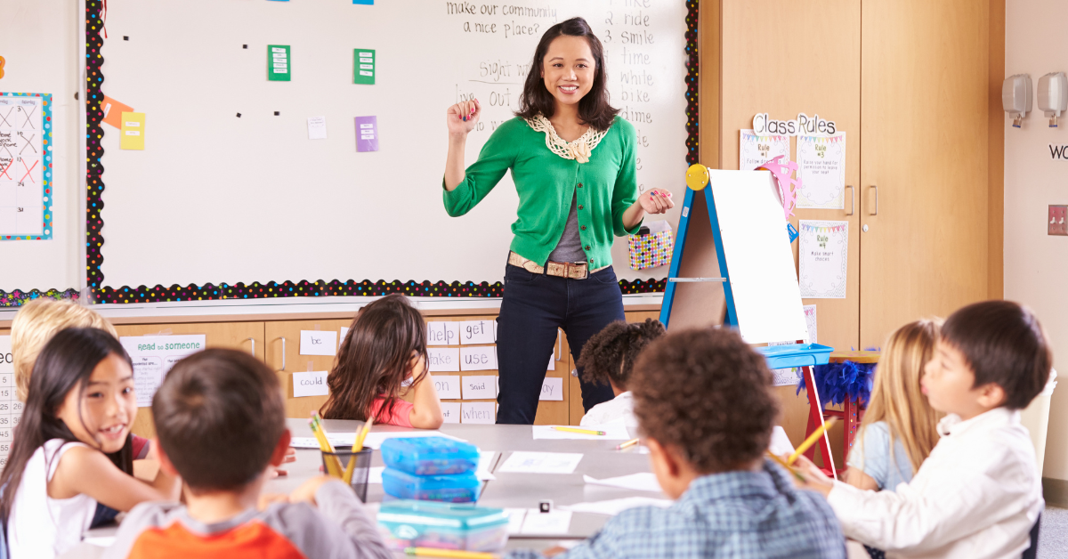 teacher and happy elementary students in classroom