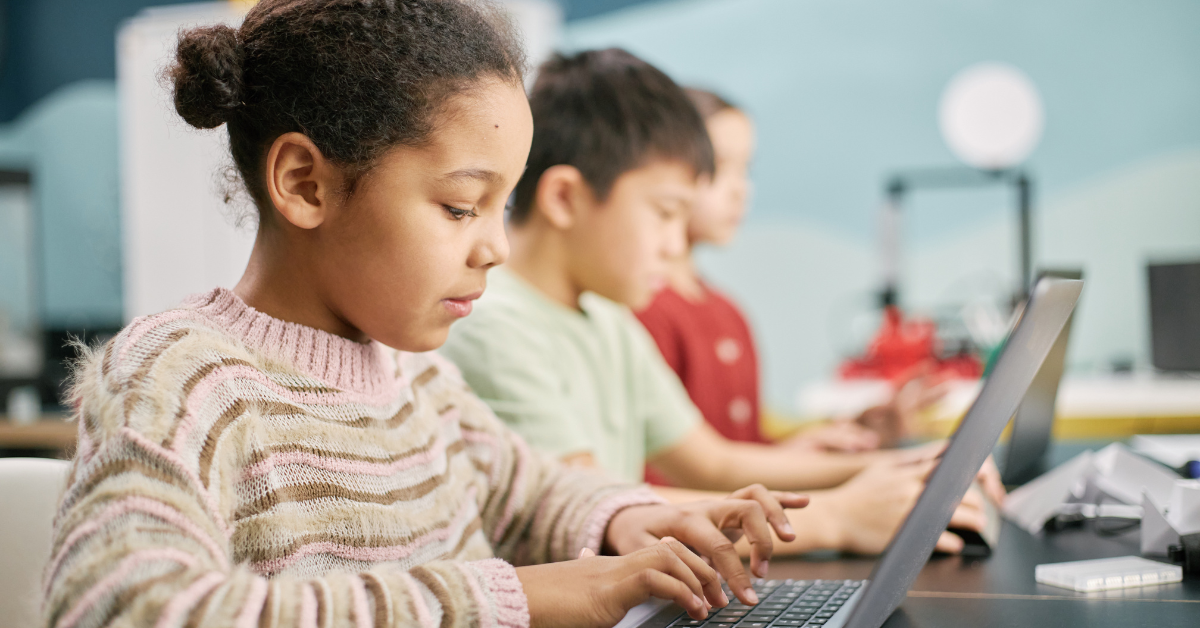 young girl uses a laptop in school